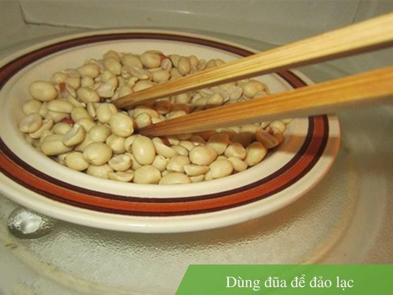 Bước 2: Dùng đũa để đảo lạc