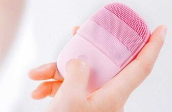 Máy rửa mặt sóng âm inFace màu hồng cầm trên tay